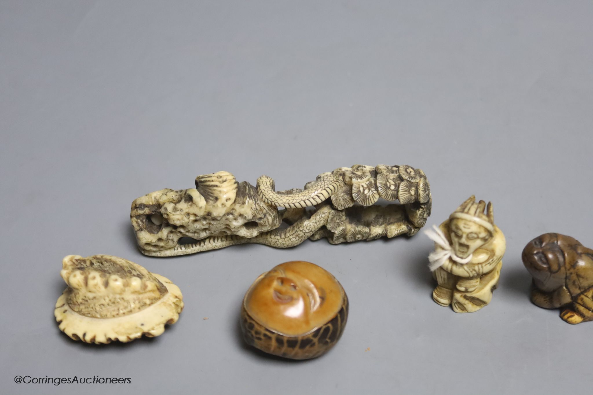 Two Japanese stag antler netsuke, a stained ivory tiger netsuke, a walrus ivory carving and a nut mask netsuke
